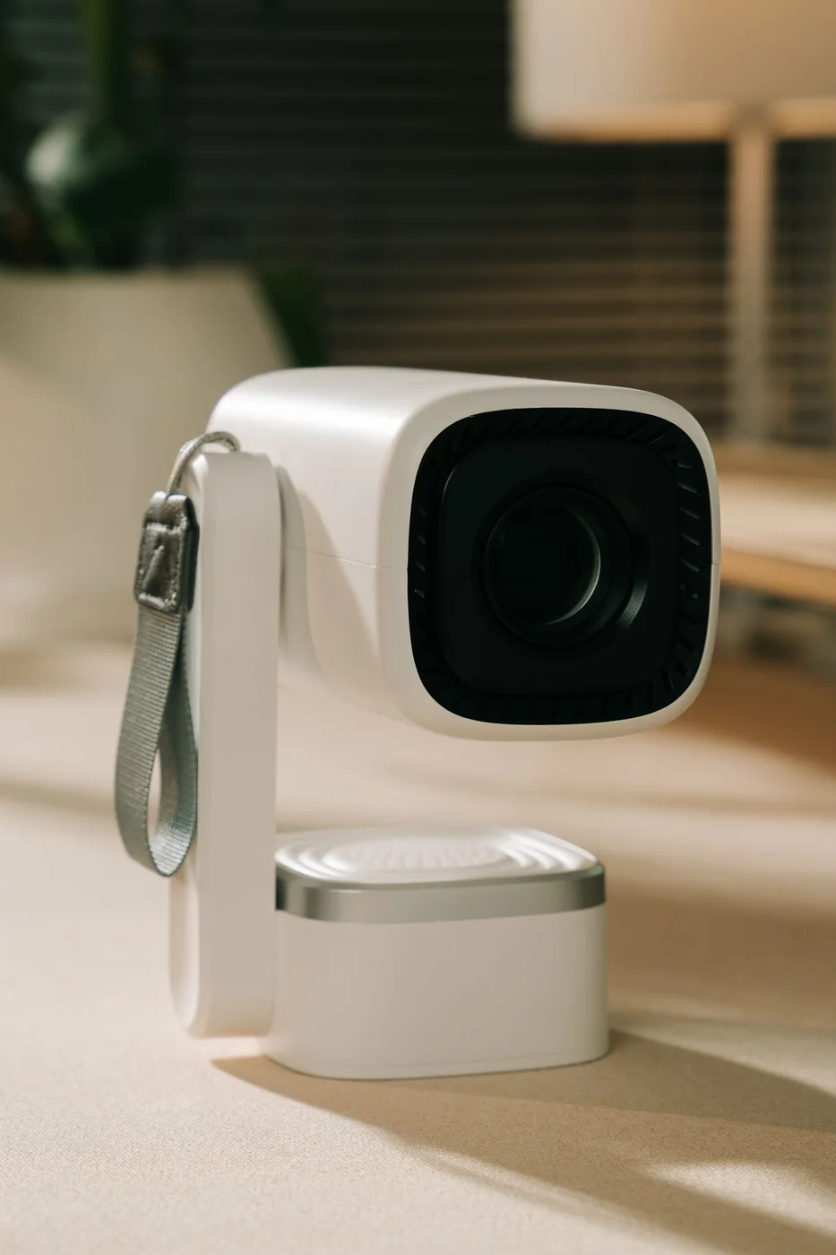 White portable projector resting on a desk