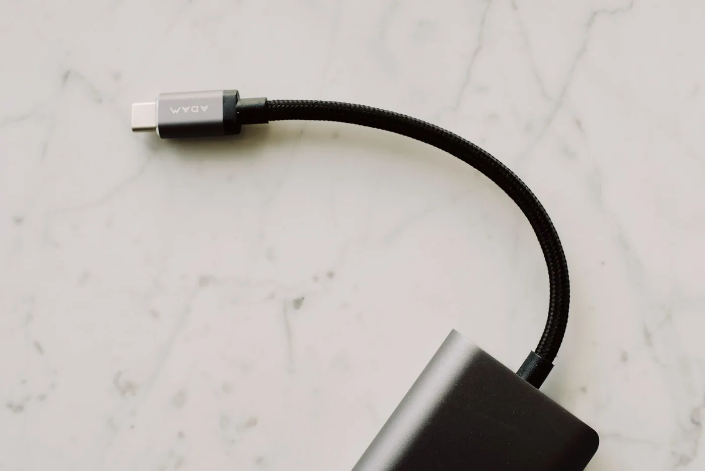 Black braided USB-C cable resting on a marble surface